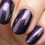 Close-up of dark purple metallic nails