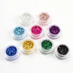 Close-up of various acrylic nail glitter powders in different colors and sizes.