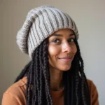 Woman wearing a chunky knit beanie over her locs