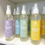 Variety of shower steamer spray bottles with different labels indicating various scents