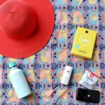 Festival Survival Pack Essentials: Sunscreen, hat, reusable water bottle, first-aid kit, portable charger.