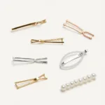 A variety of minimal hair clips in different styles and materials like metal, acetate, and pearl.