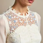 Close-up of the intricate embroidery and eyelet lace on a cream-colored Ulla Johnson Annie Top