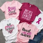 Variety of breast cancer awareness t-shirt designs displayed on a table